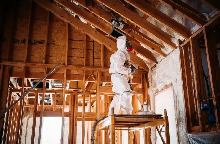 Professional-in-white-suit-with-face-mask-insulates-an-attic